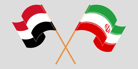 Crossed and waving flags of Iran and Yemen
