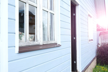 A front part of a modern scandinavian tiny wooden house painted in blue