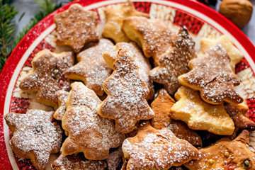 Homemade Christmas tree cookies in a red plate close-up. Diy christmas baking and sweets concept