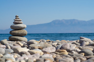Fototapeta na wymiar Balanced stones on a pebble beach during sunset
