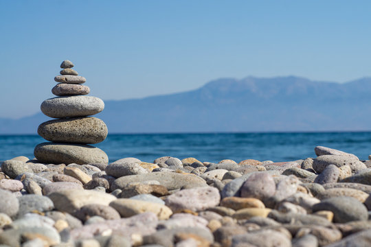 Balanced stones on a pebble beach during sunset