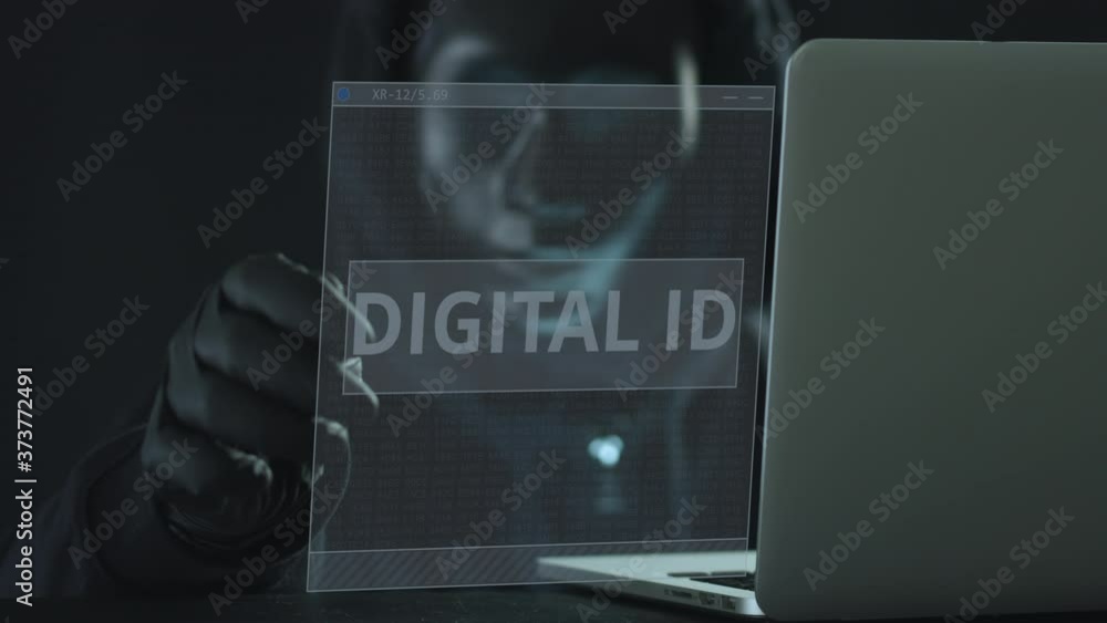 Poster a hacker wearing black mask pulls digital id tab from a laptop. hacking concept