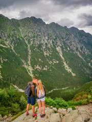 A couple kissing each other on the top of the mountain