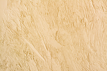 Textured background. Decorative plaster of walls, external finishing of the facade of the house. The texture is beige.