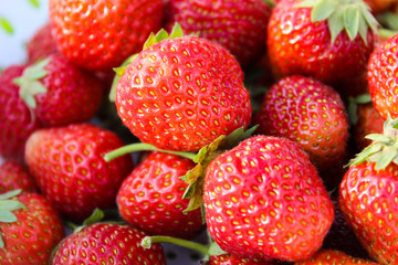Background from freshly harvested strawberries, directly above. Summer photo with beautiful and juicy strawberries. Fresh organic berries macro. Red ripe. Close up, isolated. 
