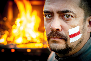 Man with a painted a white and red flag of the revolution on his face. Protest against the...