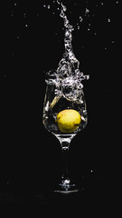 fresh water splashing, while a lemon falling in to a wine glass.