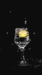 fresh water splashing, while a lemon falling in to a wine glass.
