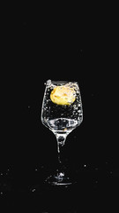 fresh water splashing, while a lemon falling in to a wine glass.