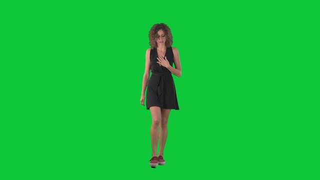 Young unwell woman having flu symptoms coughing and sneezing while walking on green screen chroma key background. 
