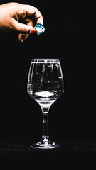 adding essence into a cup of water in a wineglass.