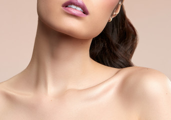 women's neck shoulder lips and collarbone on nude background 
