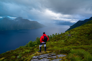 Hiker standing on top of the mountain on a foggy day