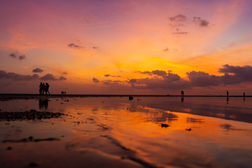 Burning bright sky during sunset on a tropical beach. Sunset during the exodus, the strength of people walking on water