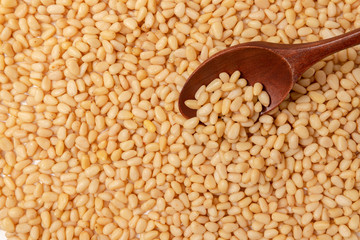 Peeled Pine Nuts. Unshelled kernels. Nuts lie in a wooden spoon.