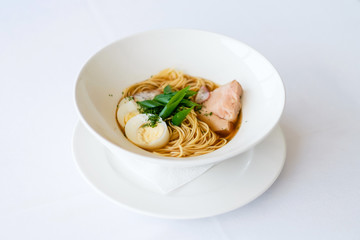 Ramen (Japanese soup with pork, egg noodles, egg, herbs and fish stock). Pretty homemade meal. Cooking and baking food while quarantining  at home during the coronavirus pandemic.
