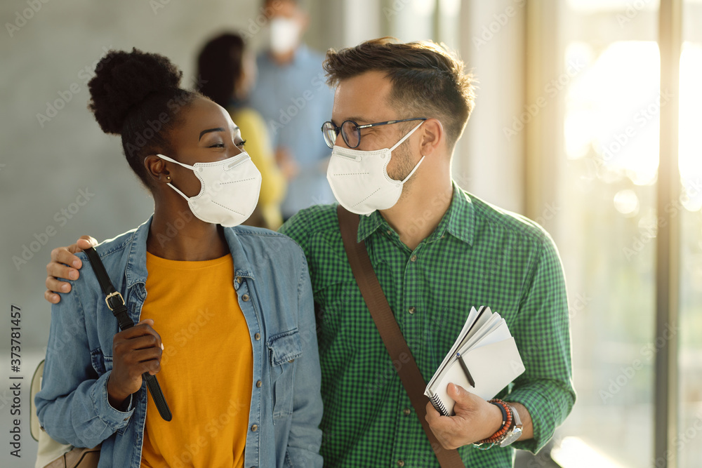 Poster Happy embraced college couple with protective face masks walking through a hallway.