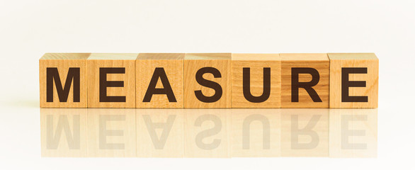 Measure. The inscription on wooden blocks on a white background. Business.
