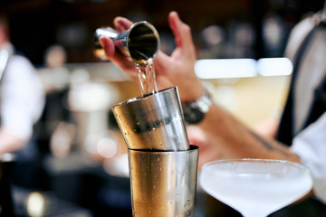 bartender in white shirt preparing a cocktail