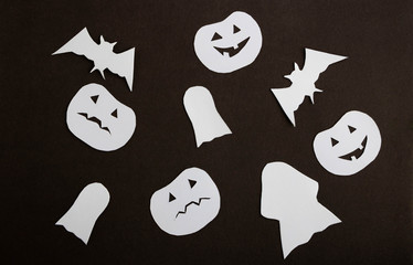 The concept of the Halloween holiday. Halloween decorations, pumpkins, bats, ghosts on black background background. Flat bed, top view