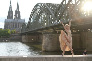 A beautiful ballet dancer ballerina outdoors ,Ballerina dancing on the bridge  in Cologne City .