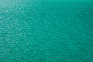 Blue tones water waves surface as background. Turquoise clean water of lake