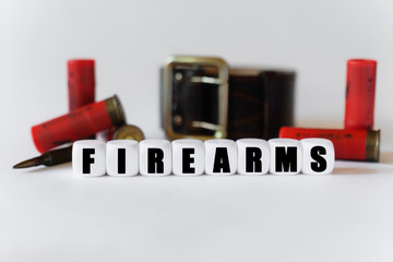 Against the background of cartridges and a military belt, cubes with the inscription - FIREARMS
