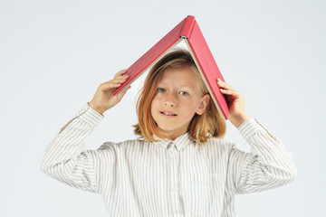 Teenager girl holding an open book above her head. Isolated background.