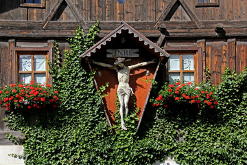 antica casa in legno con crocifisso a Sarentino (Bolzano)