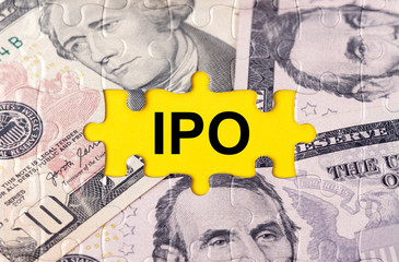 Fototapeta premium Puzzle with the image of dollars in the center of the inscription -IPO