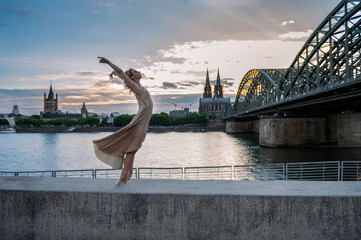 A beautiful ballet dancer ballerina outdoors ,Ballerina dancing on the bridge  in Cologne City .