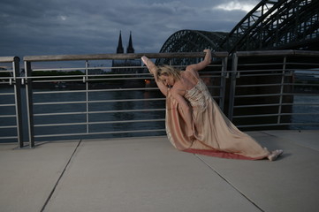 Fototapeta na wymiar A beautiful ballet dancer ballerina outdoors ,Ballerina dancing on the bridge in Cologne City .