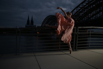A beautiful ballet dancer ballerina outdoors ,Ballerina dancing on the bridge  in Cologne City .