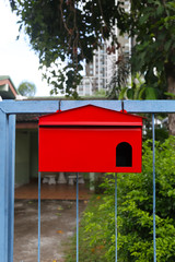 Red mailbox Hanging on the home fence.