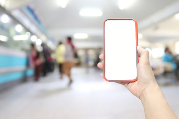 Hand of a man holding smartphone device in the hospital blur background.