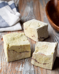 Yellow cubes of organic marshmallow, magazine photo on a wooden background, close up