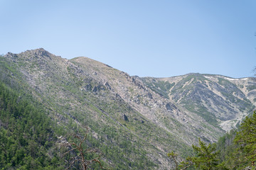 Russia, Irkutsk region, Republic of Buryatia, july 2020: scenic picture huge mountains covered with green trees around baikal lake