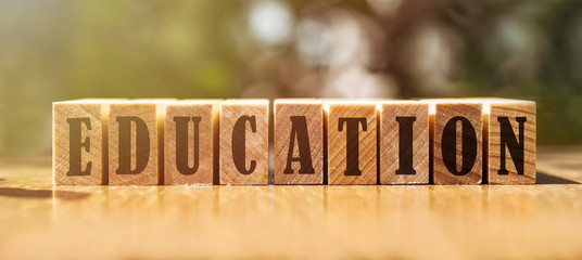 Education word made with building wooden blocks on table in sunlight