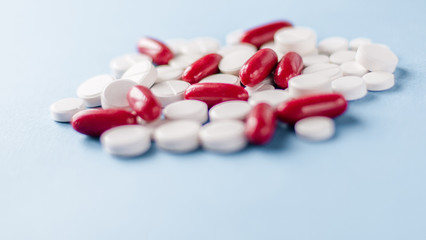 Pharmacy theme, white and red medicine tablets antibiotic pills on blue background