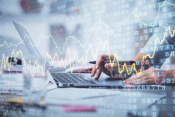 Double exposure of woman hands typing on computer and forex chart hologram drawing. Stock market...