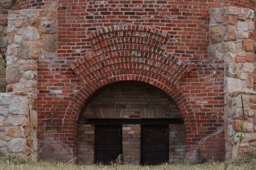 Plakat entrance to the old brick tower with stone buttresses