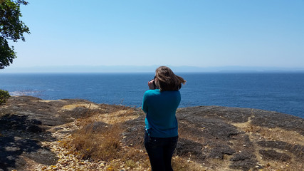 woman on a rocky beach ledge