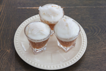 Thai Sago Dessert over topping with coconut milk contain in small glass, appetizing
