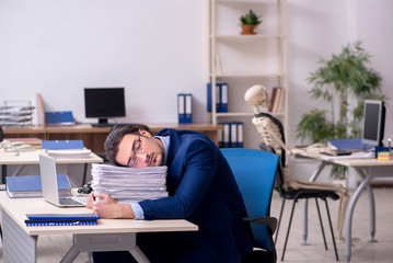 Young male employee with skeletons in the office