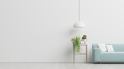 Empty living room with blue sofa, plants and table on empty white wall background.