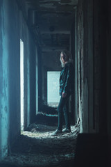 Young woman standing in dark corridor