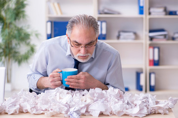 Old businessman rejecting new ideas with lots of papers