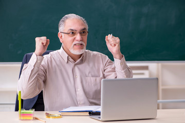 Old male teacher in the classroom