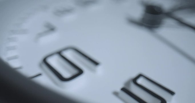 Seconds Pass 6 O'Clock, Rack Focus. Extreme macro wide angle close up as the second hand ticks past the 6 on a small alarm clock with raised 3D numbers.
