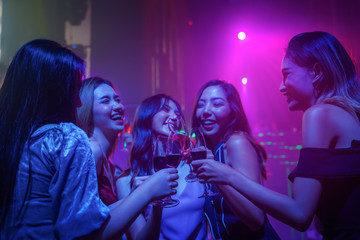 friends enjoy party in nightclub and toasting wine together